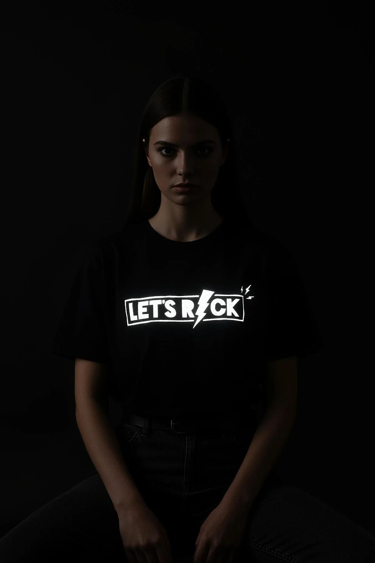 black reflective graphic t-shirt with Let's Rock lightning bolt print glowing silver-white under light, relaxed boxy fit