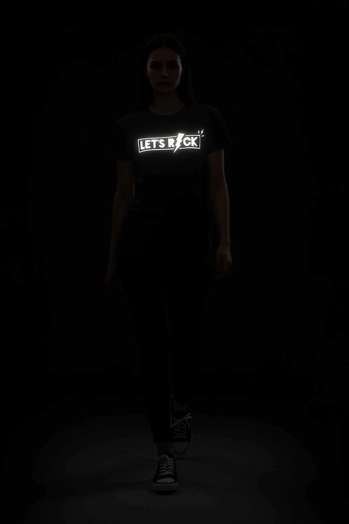 black reflective graphic t-shirt with Let's Rock lightning bolt print glowing silver-white under light, relaxed boxy fit