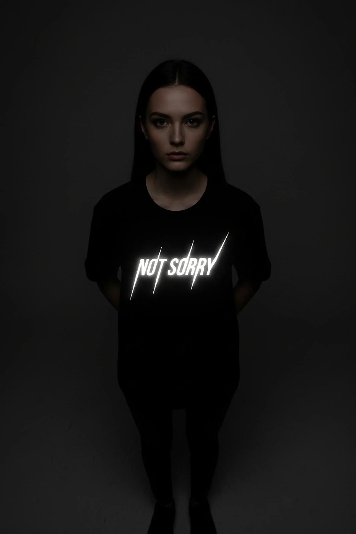 black graphic tee NOT SORRY reflective print slash mark accents close-up