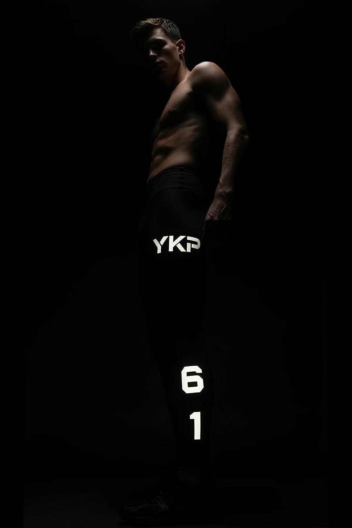 reflective number 98 detail near ankle hem of black tapered sport joggers
