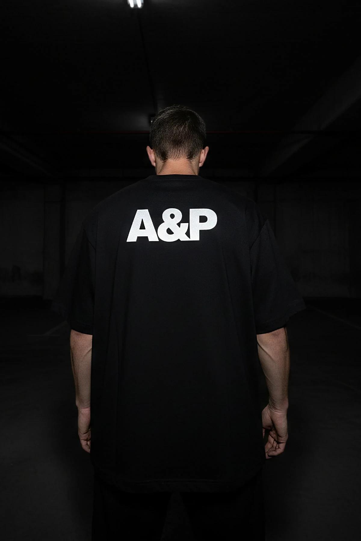 black custom print tee flat lay showing 220 gsm combed cotton fabric texture and reflective graphic
