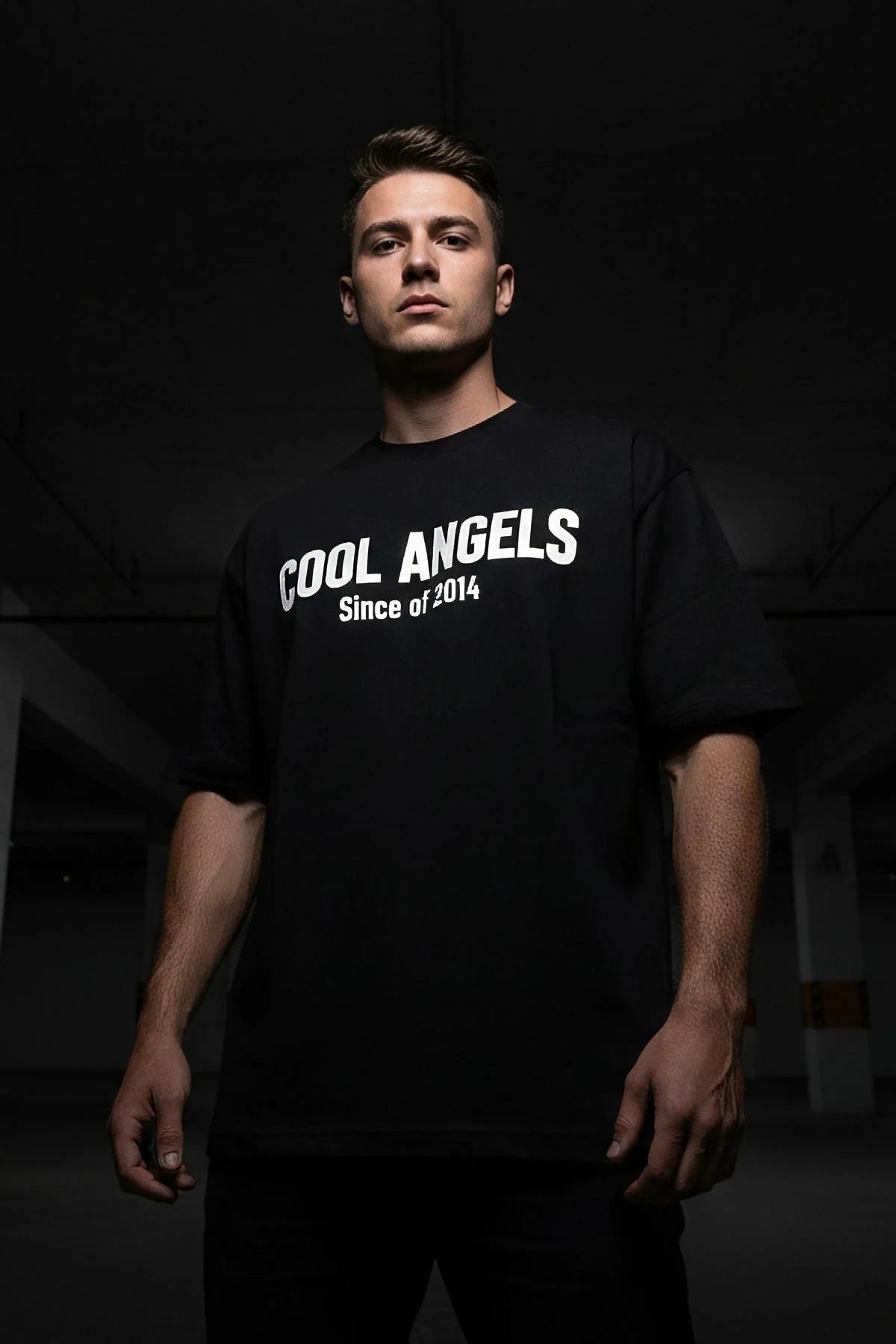 oversized black crew neck t-shirt with luminous COOL ANGELS print worn in dark environment