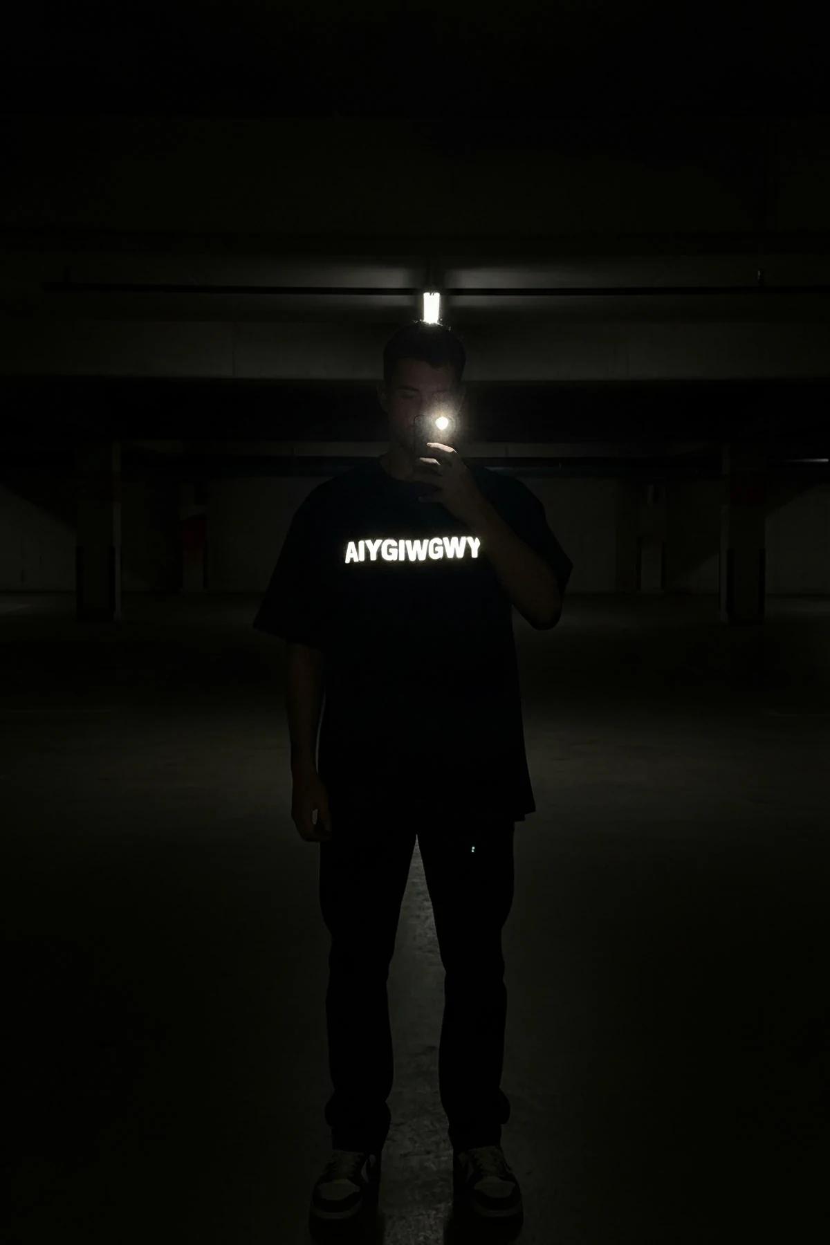 black oversized cotton t-shirt with white reflective custom block-letter chest print, drop-shoulder street fit