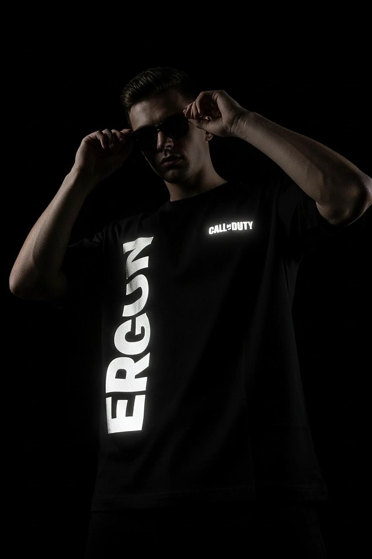 close-up of retroreflective heat-transfer print on black cotton t-shirt showing bold two-line text