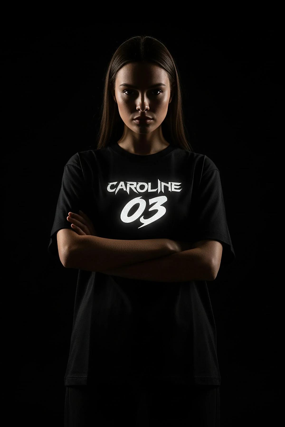 close-up of retroreflective white name print on black cotton t-shirt glowing under direct light