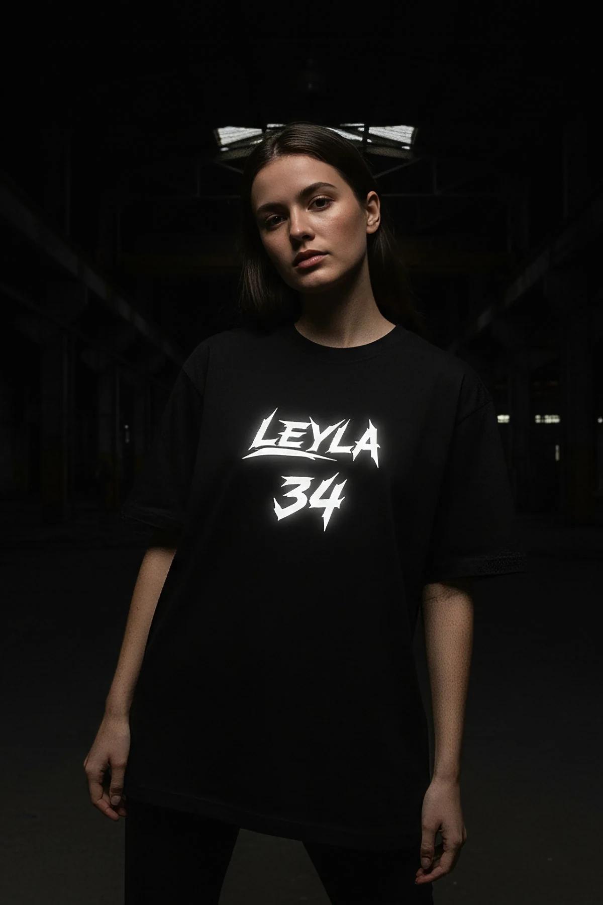 Black cotton oversized tee chest detail showing bold white graffiti print in two-line layout
