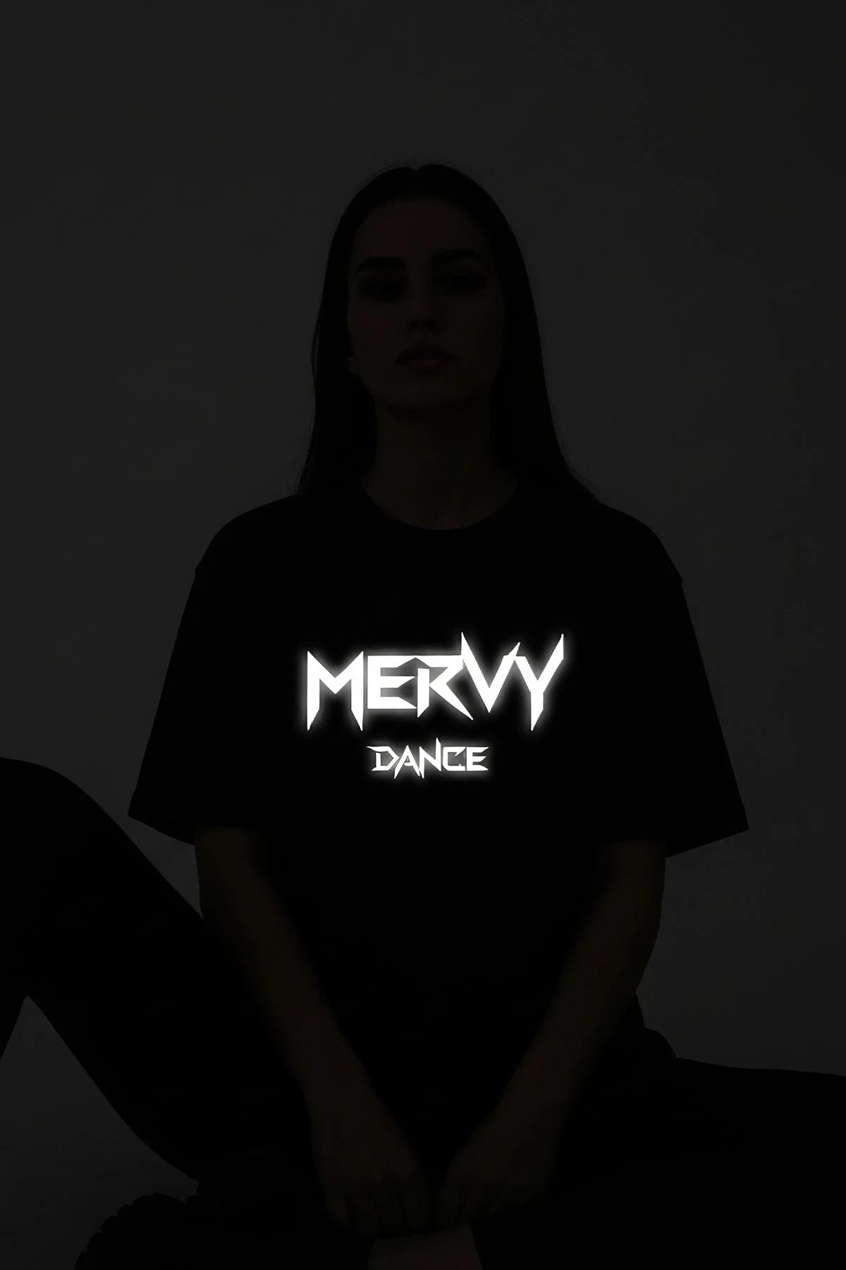 black reflective graphic tee custom print glowing under direct light in dark setting