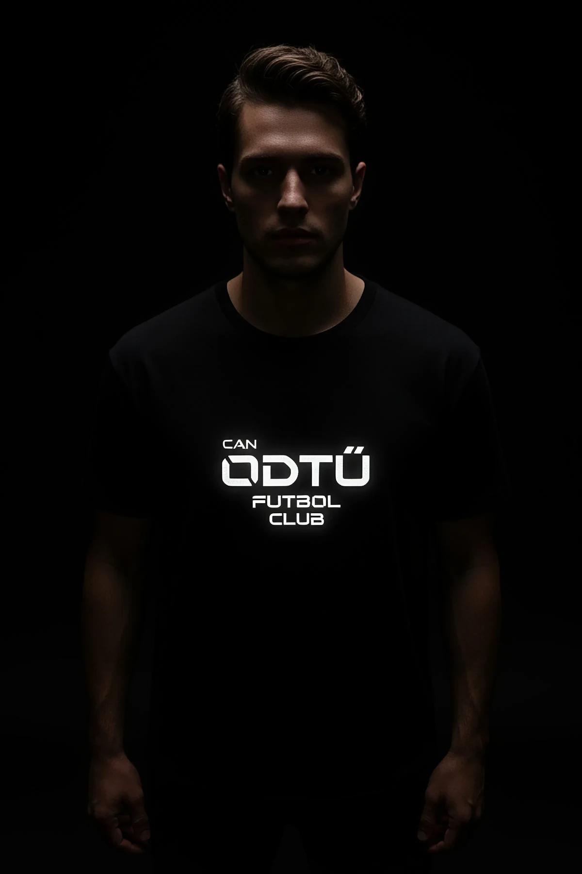 black reflective t-shirt with bright white glowing logo print worn in low-light night setting
