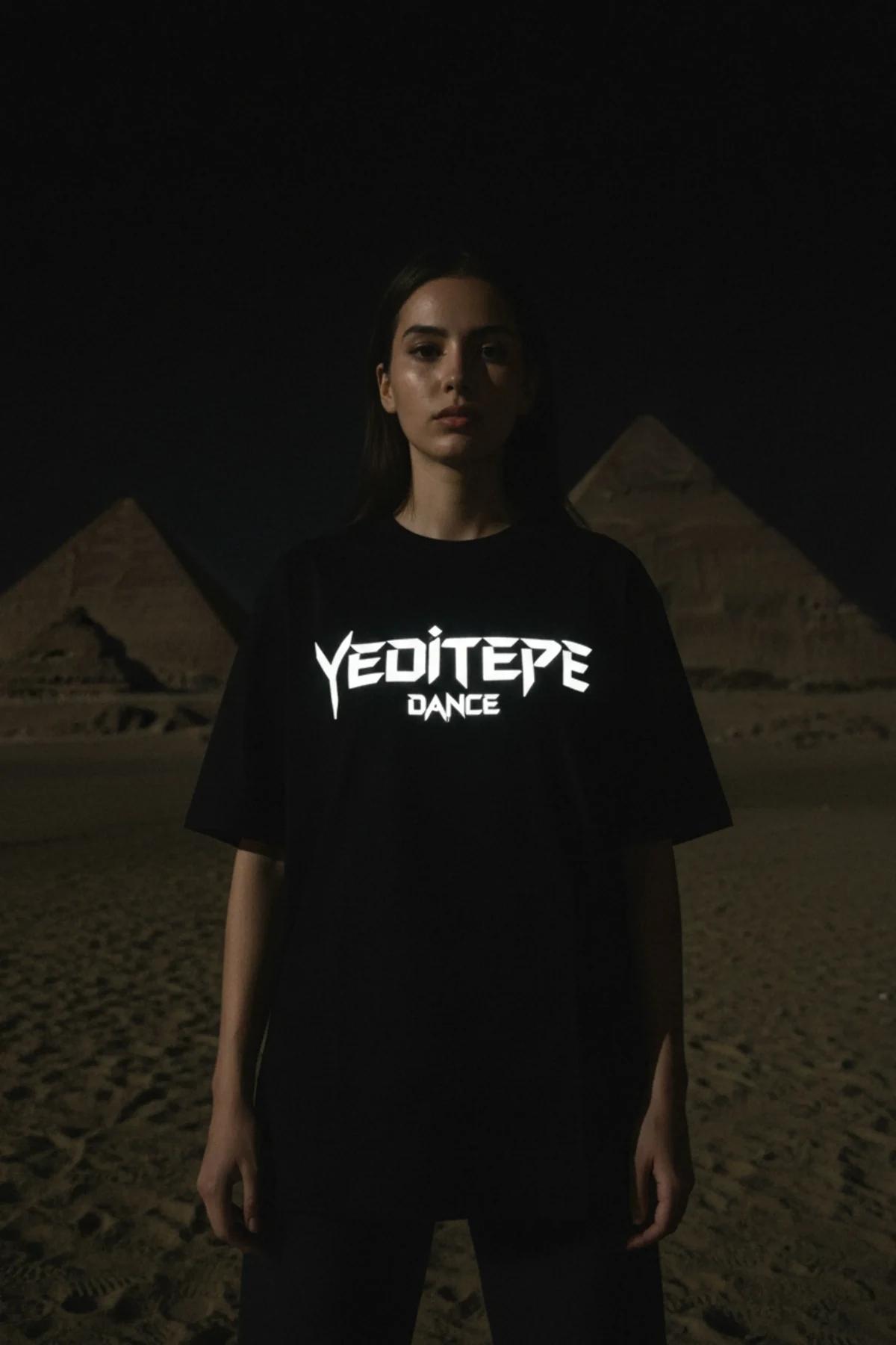 black oversized reflective graphic t-shirt with bright white custom chest print glowing under direct light