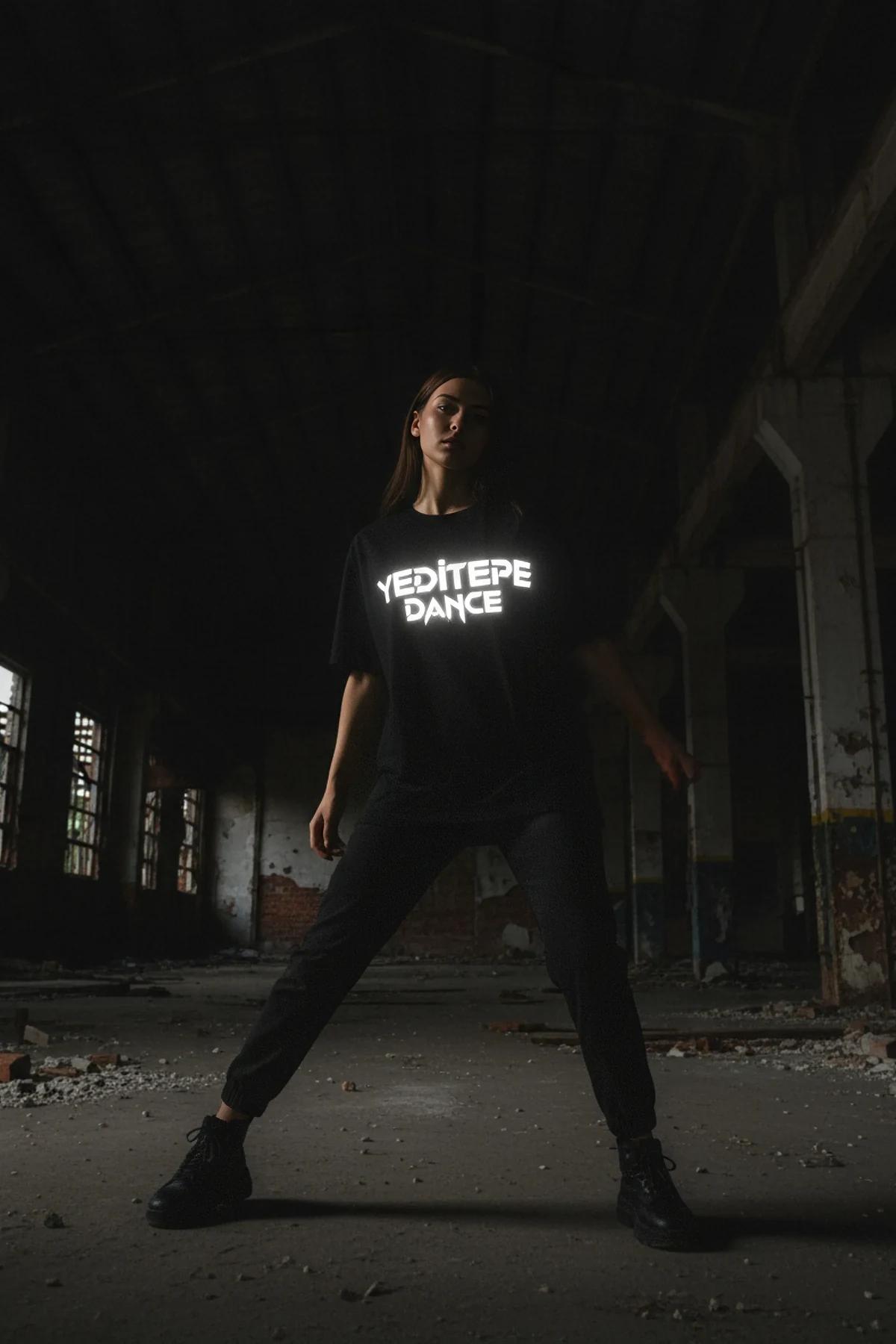 black oversized reflective graphic t-shirt with bright white custom chest print glowing under direct light