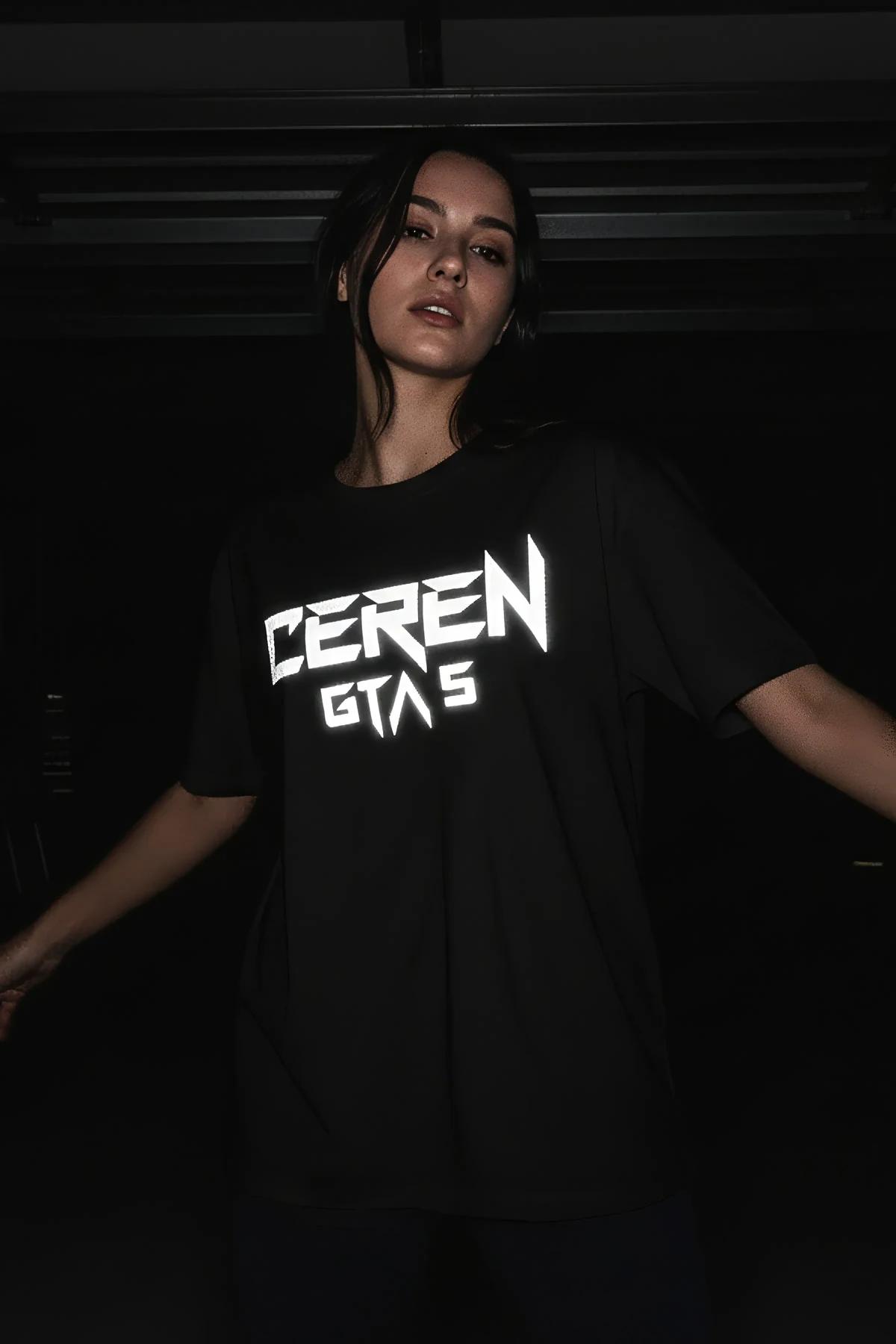 black oversized t-shirt with glow-in-the-dark Ceren GTA 5 angular graphic worn in dark studio setting