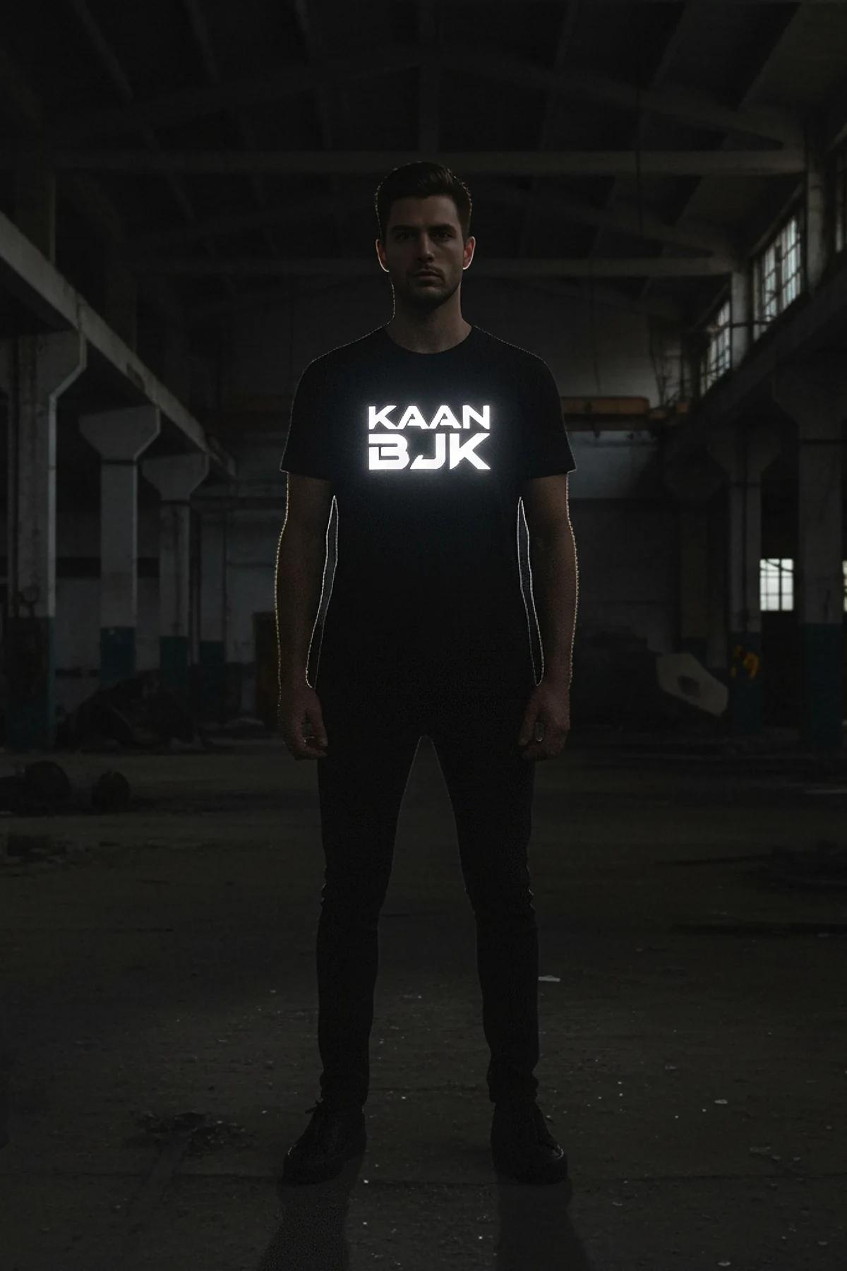black oversized reflective logo t-shirt with glowing white chest graphic on male model in dark warehouse