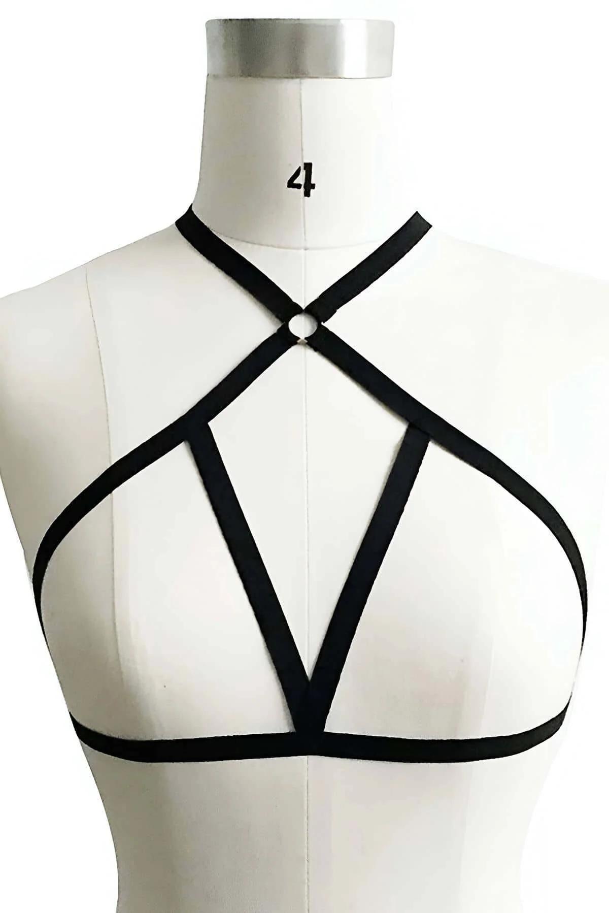 black Spandex chest harness five straps crossing at silver O-ring, worn over dark outfit, front view close-up
