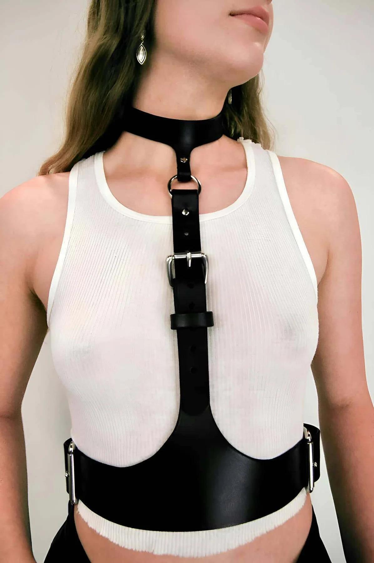 Siyah vegan deri boyun bağlantılı korse harness, gümüş dikdörtgen toka ve D-ring, beyaz atlet üzerinde