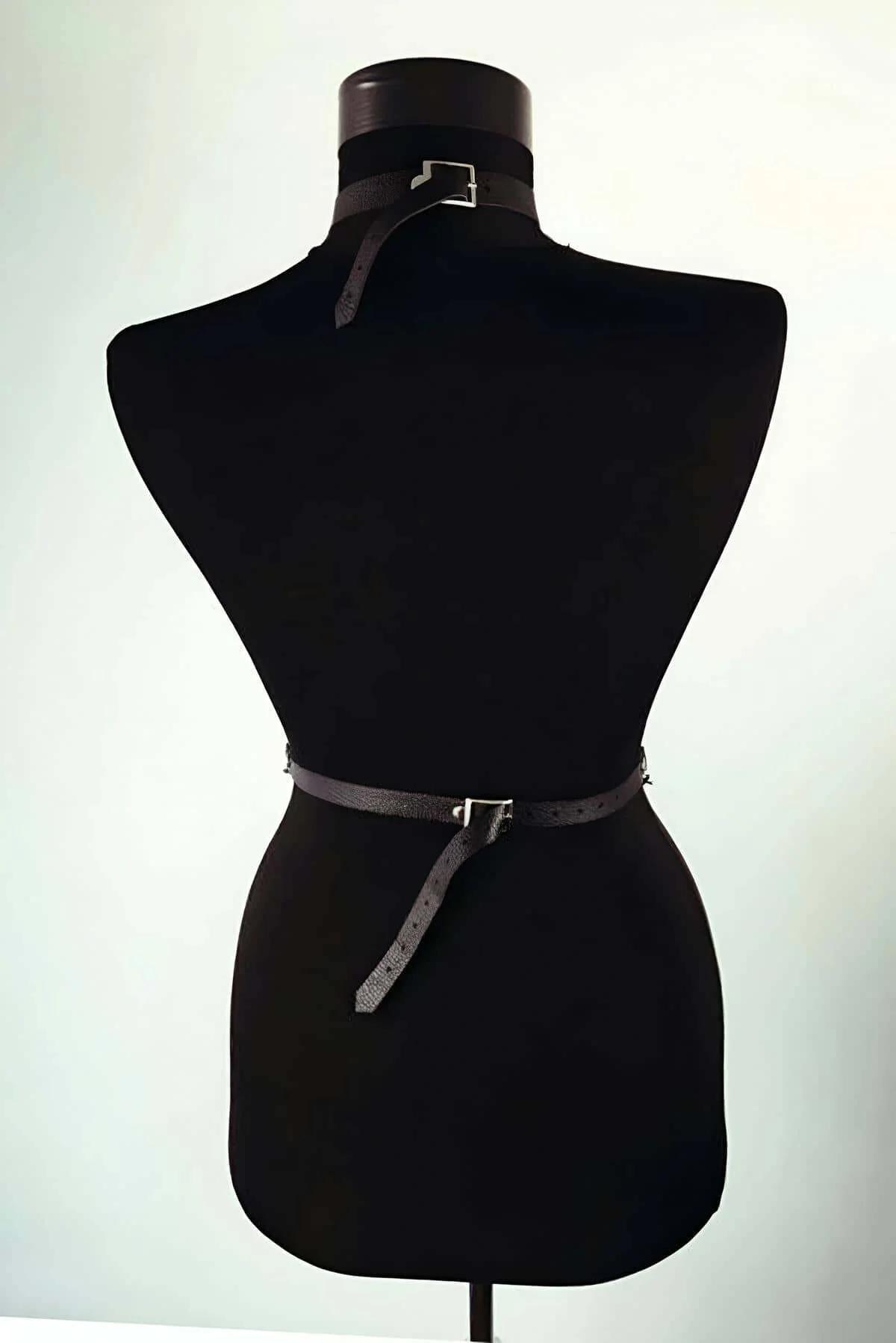 woven cross-strap waist belt section with silver buckle on black faux leather body harness
