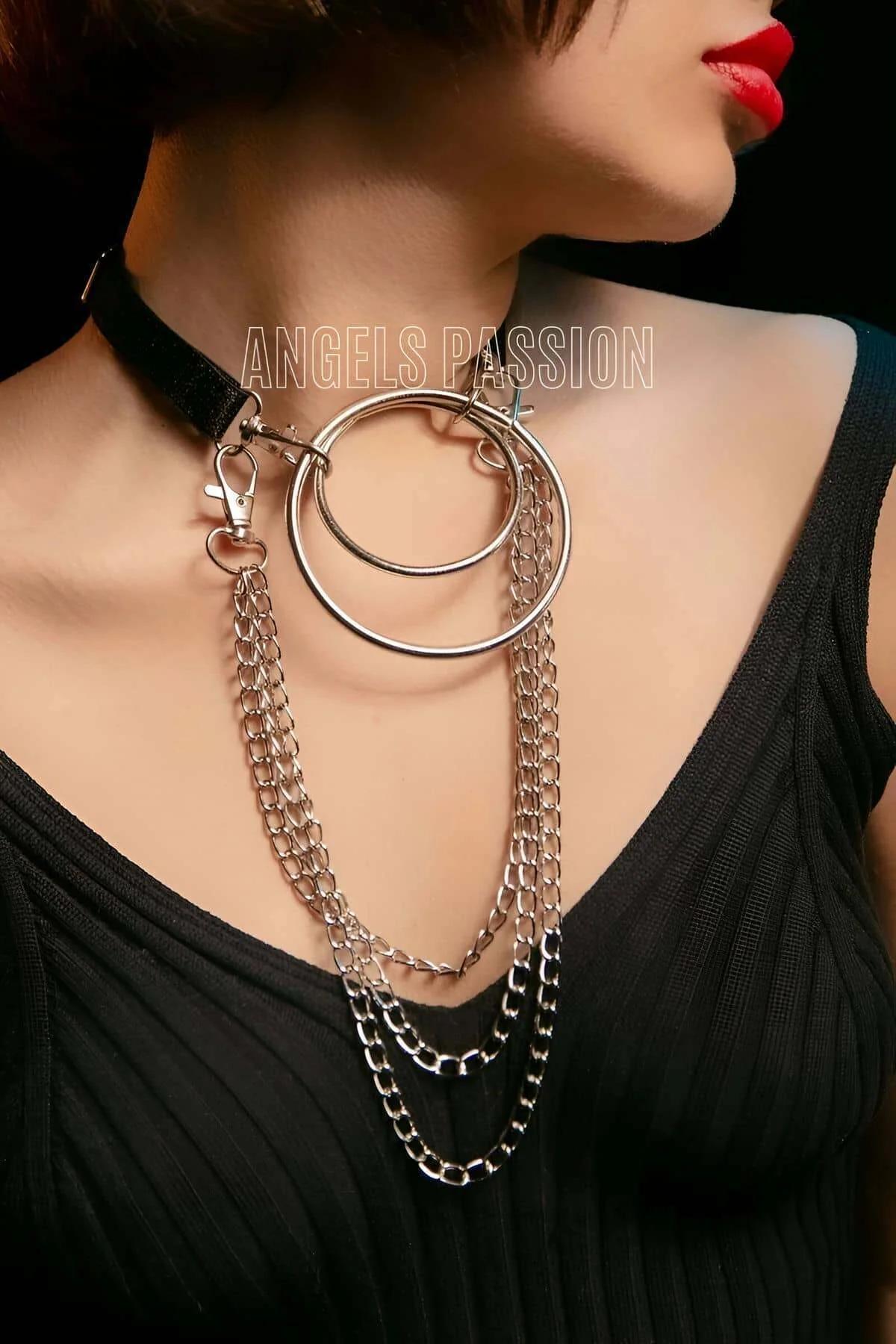 siyah elastik choker bant üzerinde iç içe gümüş halkalar ve üç sıra zincir yakın çekim