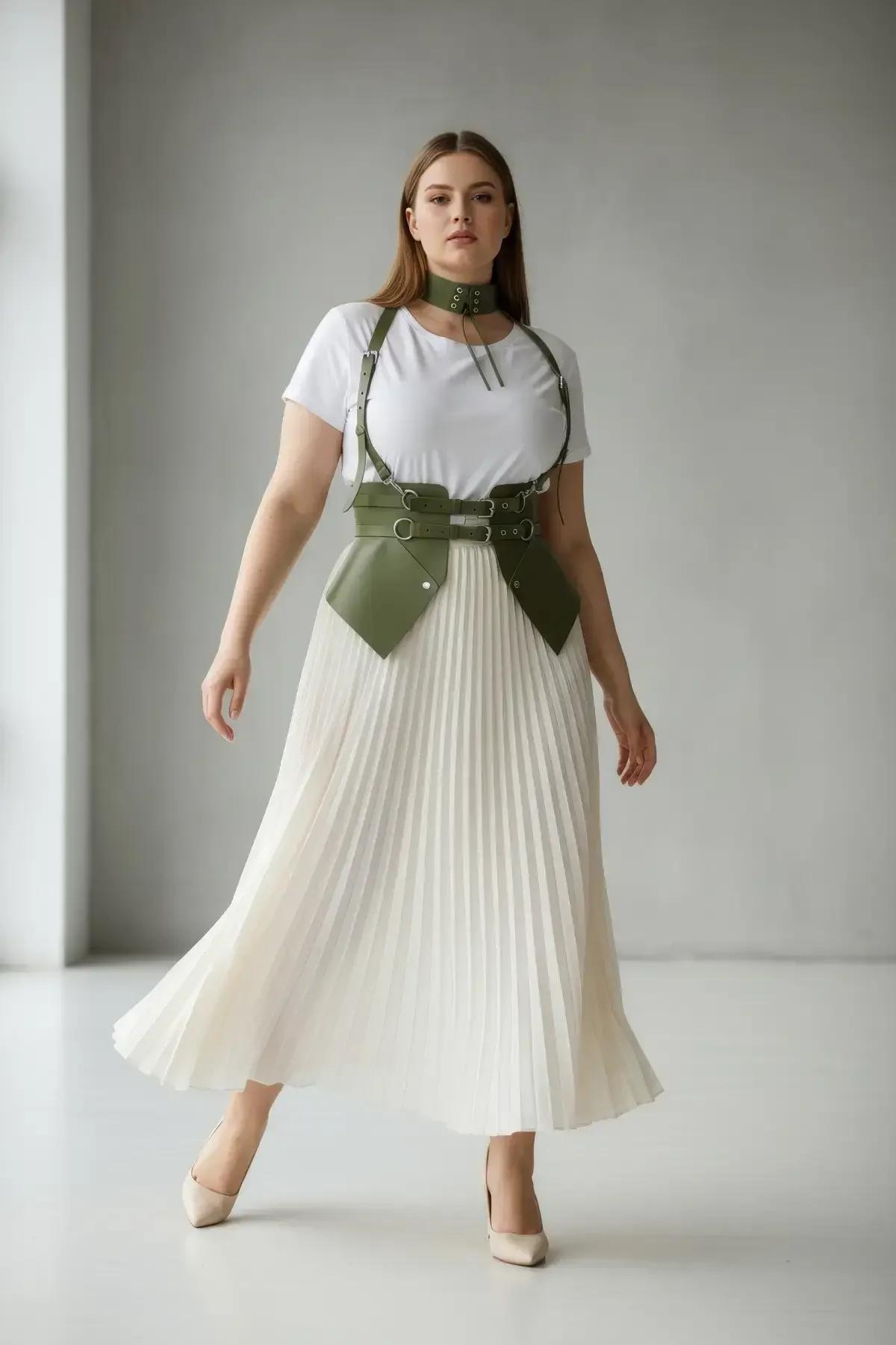 Close-up of olive green faux leather waistband with dual silver buckles and O-ring hardware on angular waspie harness
