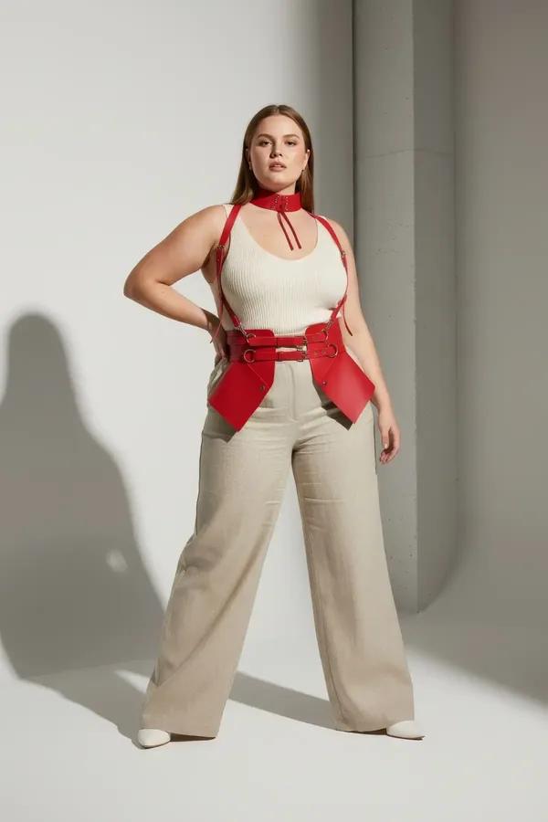 Red faux leather corset waist harness with O-rings and matching studded choker set worn over cream top