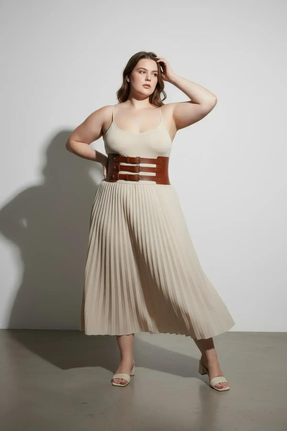 brown three-buckle waist belt layered over a white top and beige wide-leg trousers full length