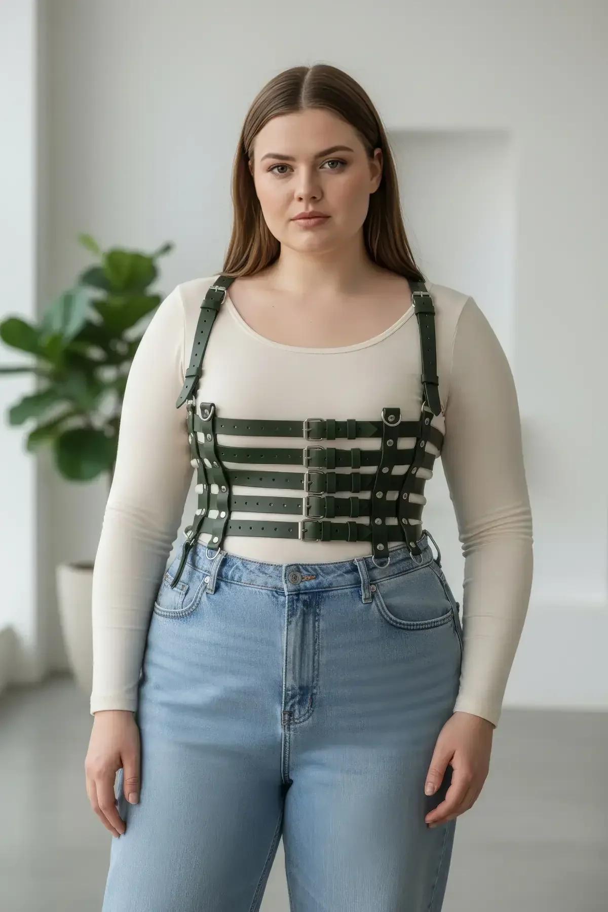 wide army green faux leather waist harness worn over white tank top with beige trousers front view