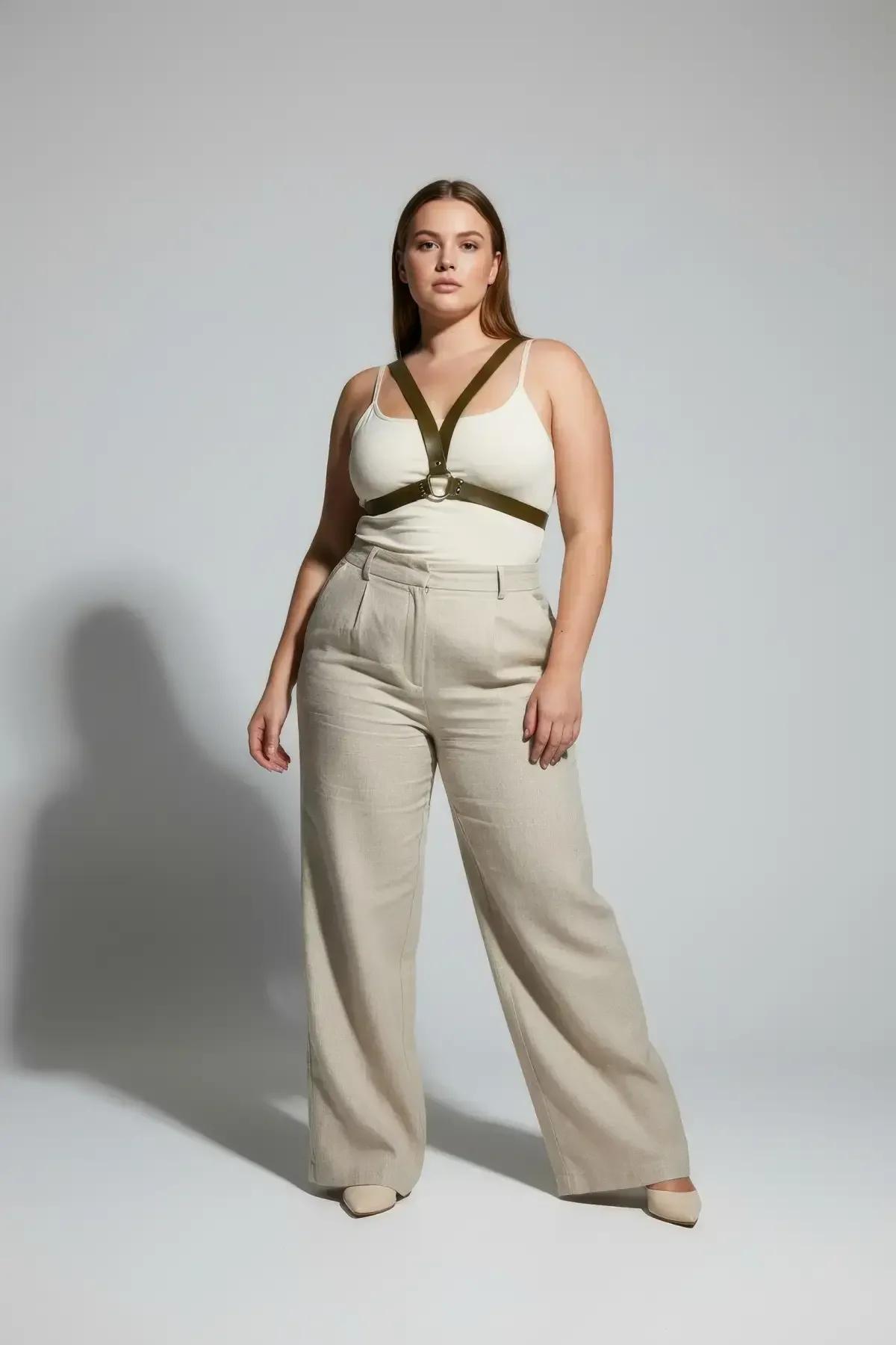 plus size olive green chest harness layered over white bodysuit with wide-leg trousers casual outfit