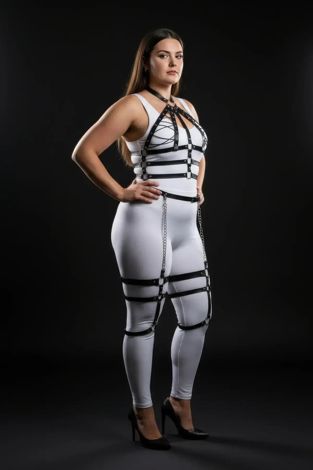 Silver-tone drop chains connecting black faux leather waist belt to thigh cuffs on plus size body harness