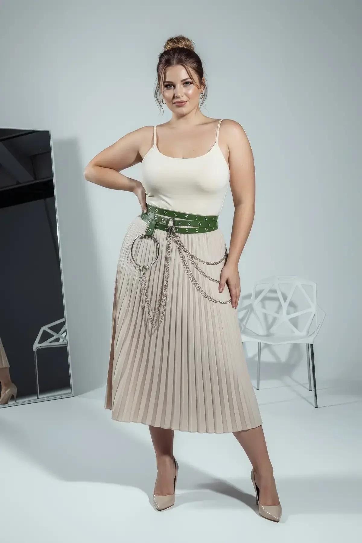 Wide green vegan leather belt worn over white tank top showing full grommet row and chain hardware
