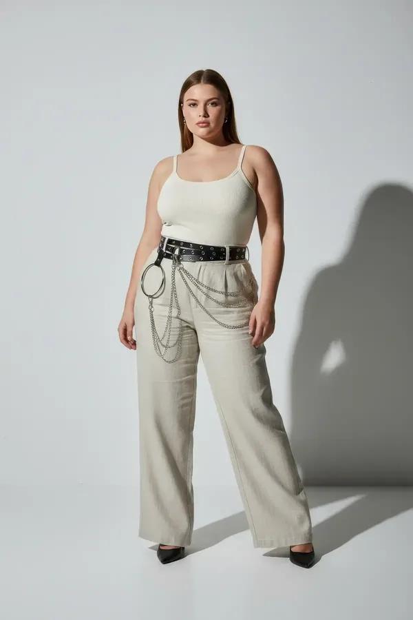 black faux leather grommet waist harness belt with silver O-ring and layered chains worn at natural waist