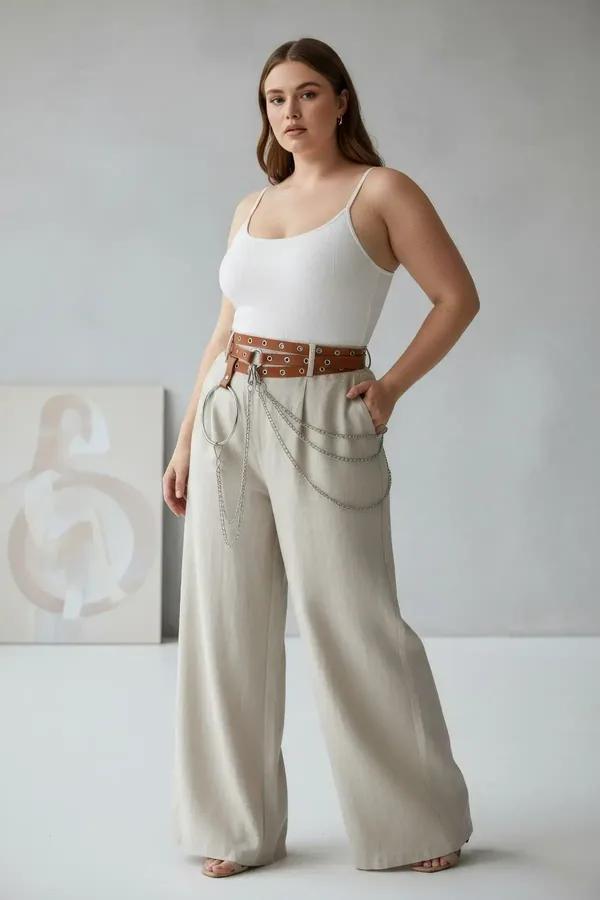 tan faux leather eyelet belt with large silver O-ring and draped chain strands worn at the waist