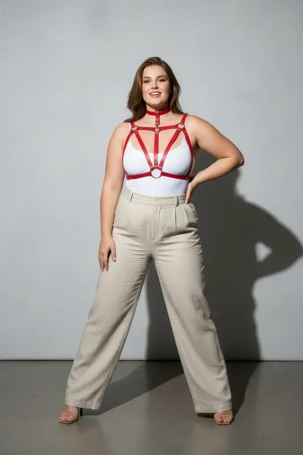 Red vegan leather chest harness with integrated choker and silver O-rings, strappy geometric cage design on plus-size model