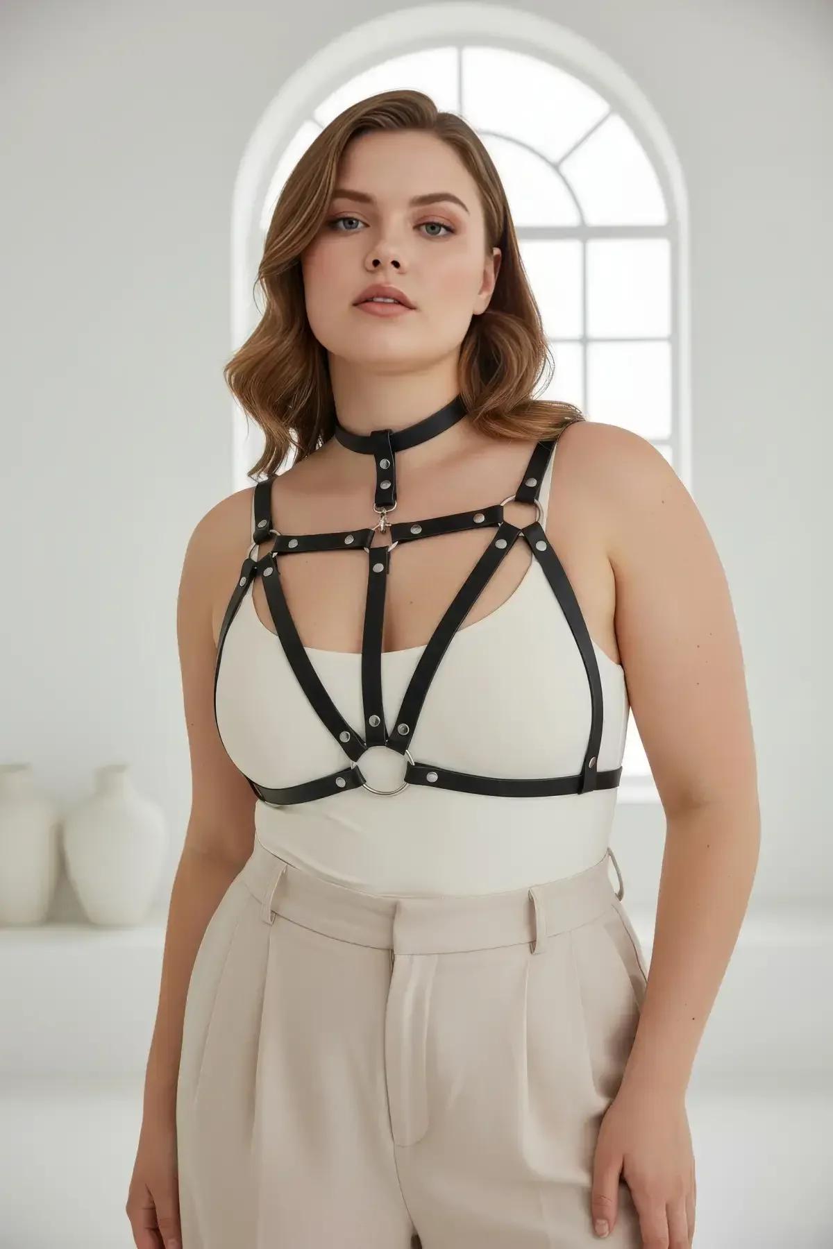 plus size model wearing black faux leather chest harness with choker over neutral bralette