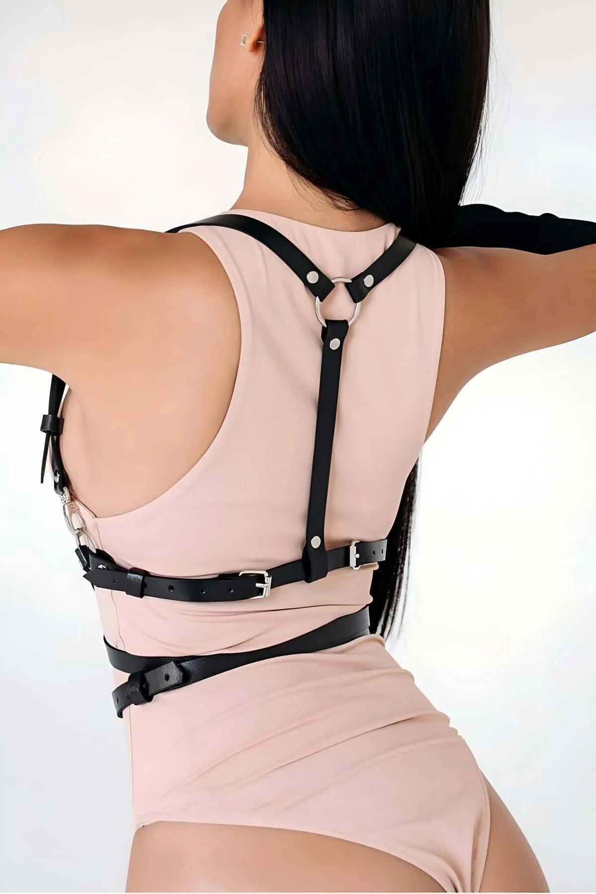 Black multi-strap chest harness worn over blush bodysuit showing full torso wrap configuration