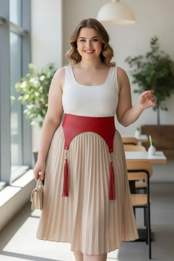 red wide faux leather waist belt harness with matching red tassels and silver hardware worn over white tank and beige skirt