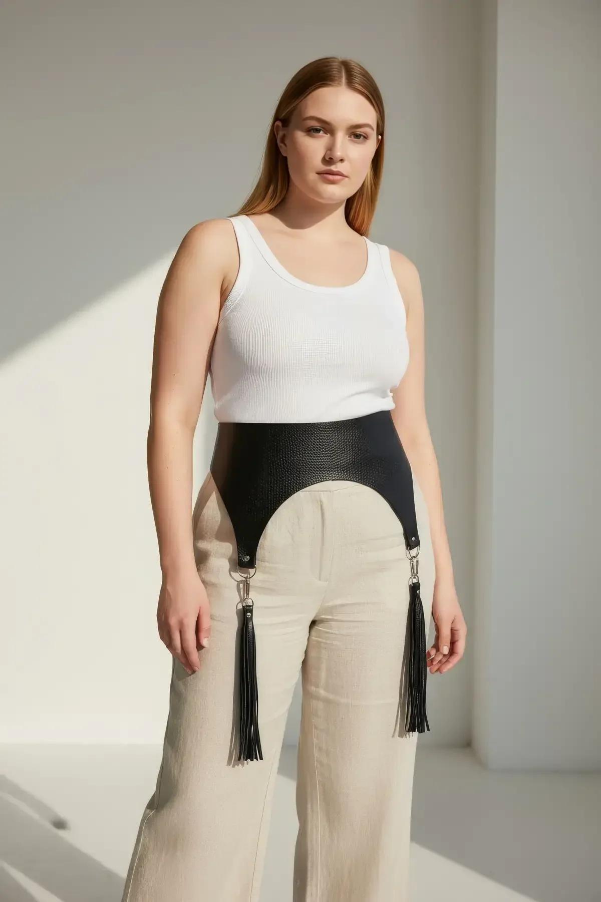 close-up of silver-tone clip ring and faux leather tassel on black waist harness