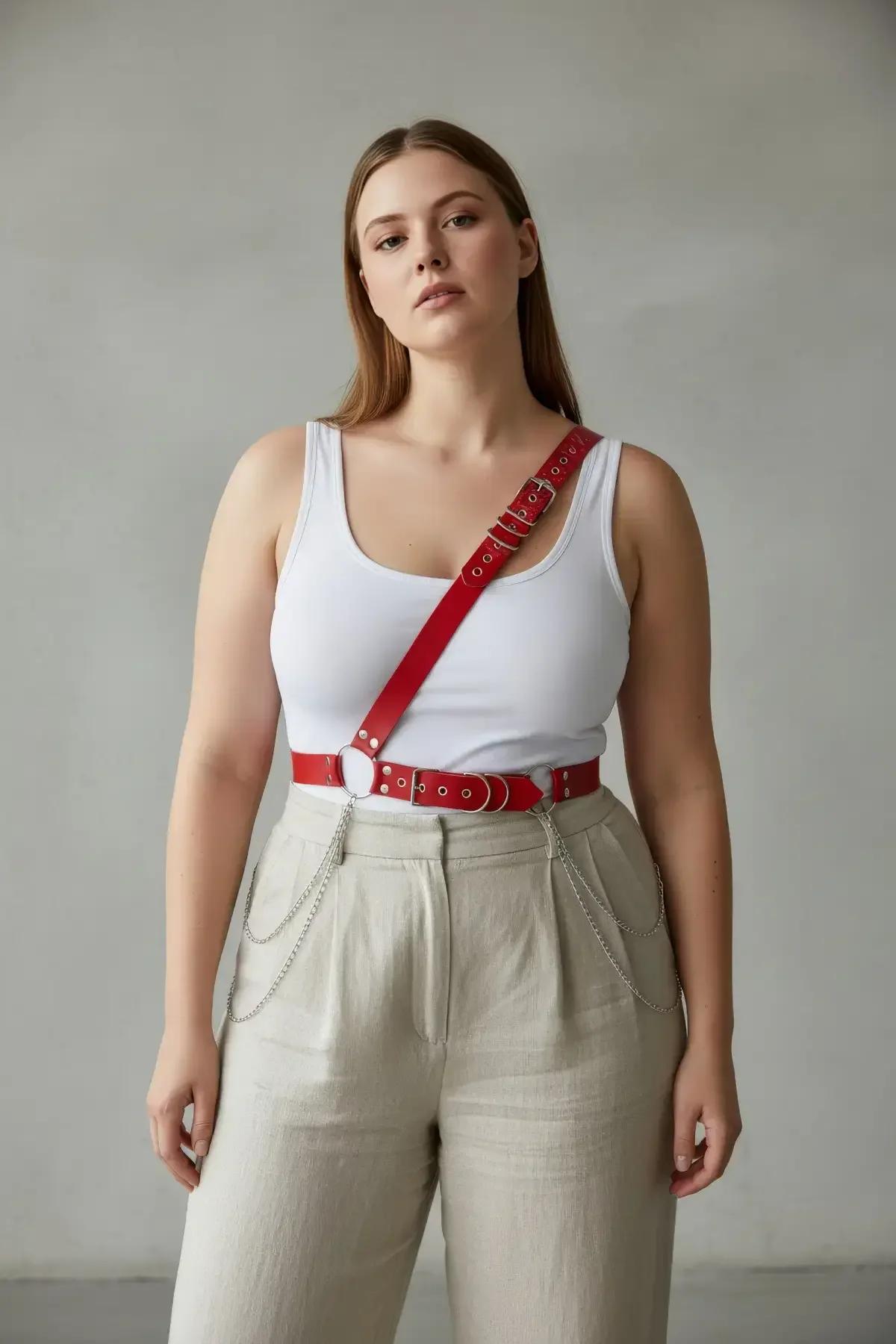 close-up of silver dome studs and O-ring detail on red faux leather chest harness strap