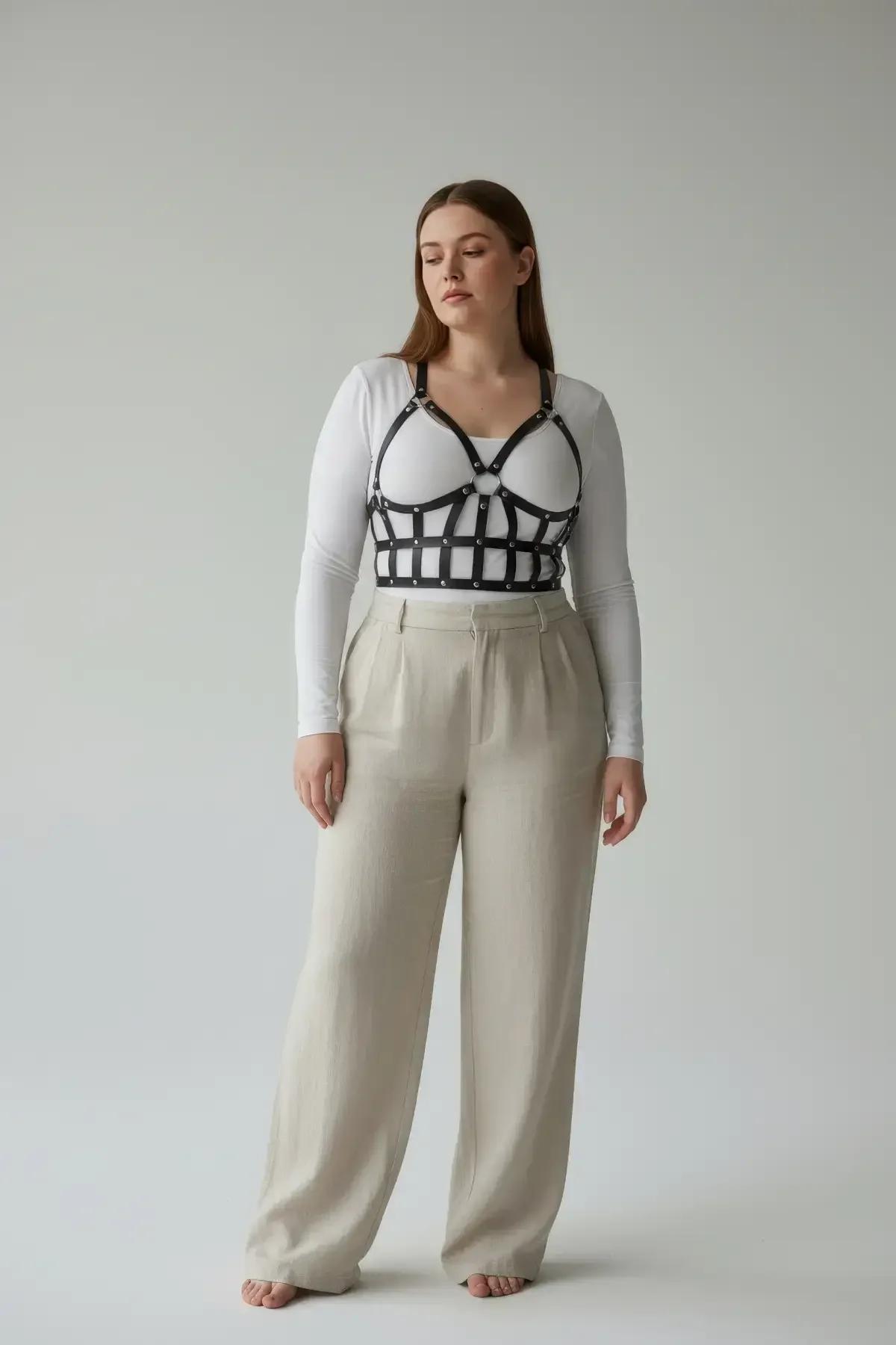 plus size black caged harness bra worn over white fitted t-shirt with high-waist jeans street style look