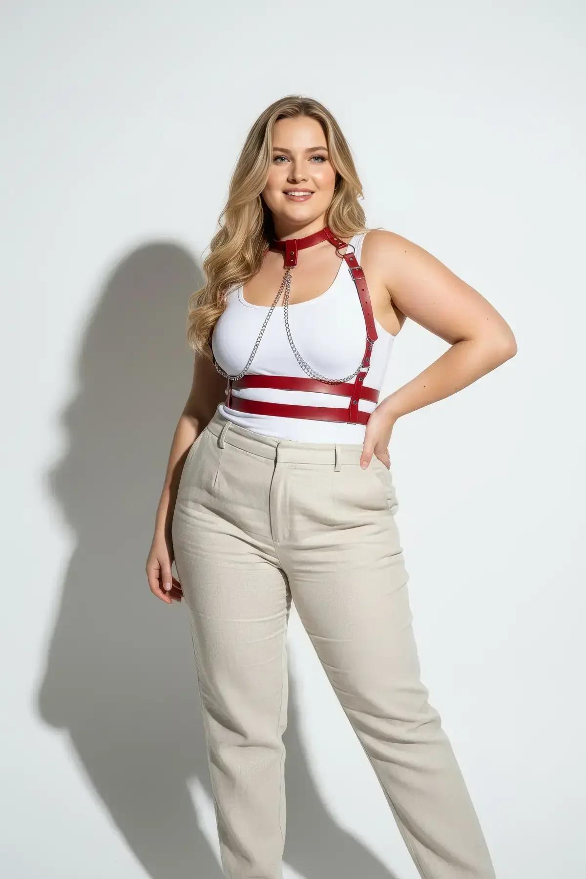 plus-size model wearing red strappy chest harness over white ribbed top with linen trousers