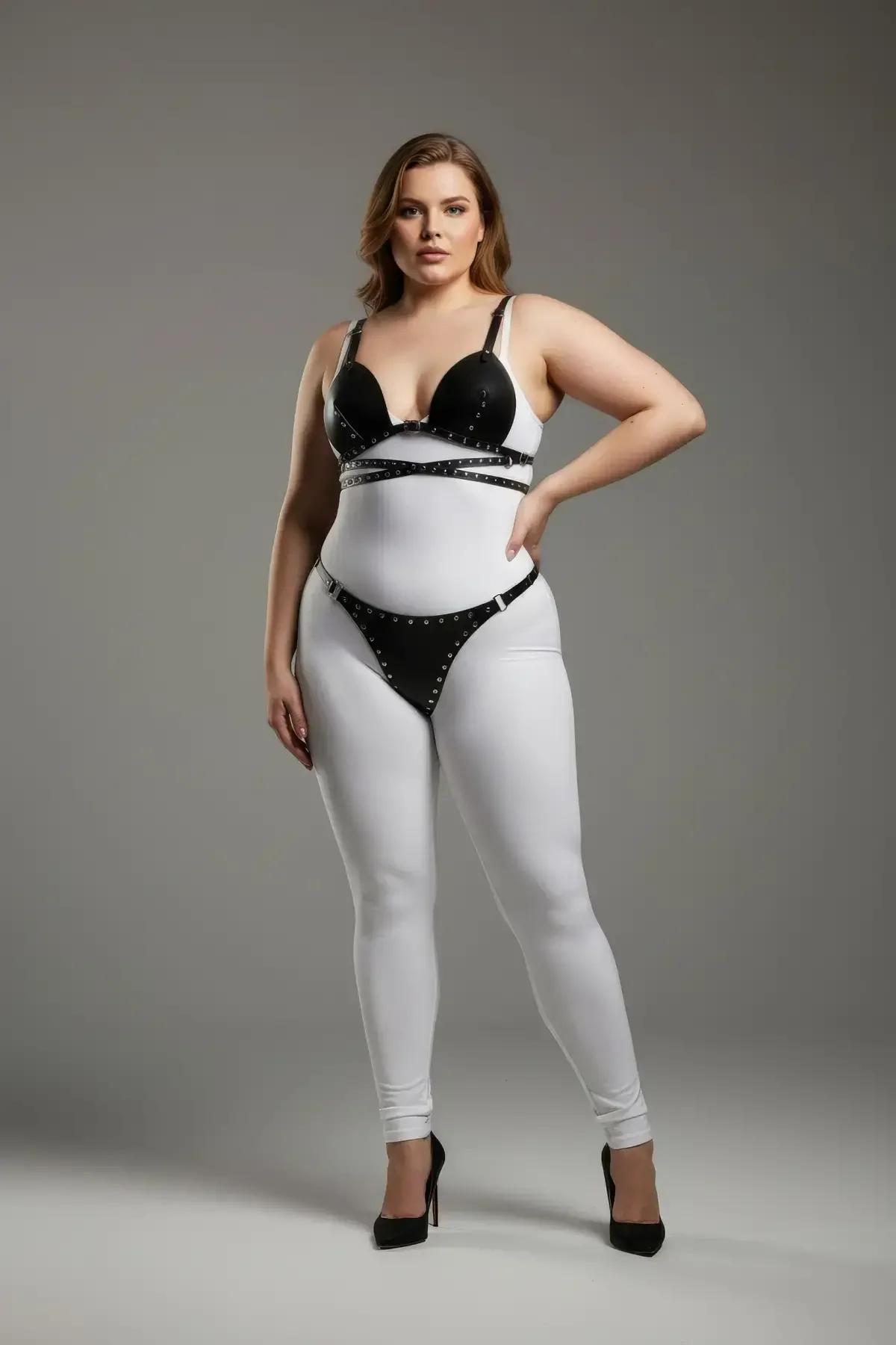 close-up of silver metal stud trim along black faux leather bra cup border and midriff cross-straps