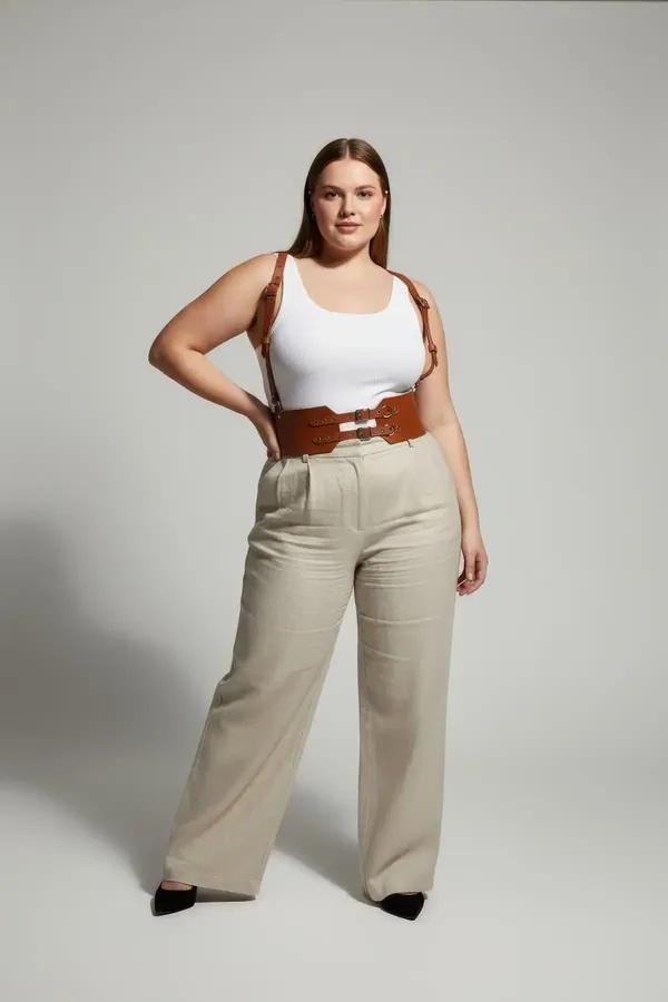 tan faux leather waist cincher harness with double buckle closure and adjustable shoulder straps worn over cream bodysuit
