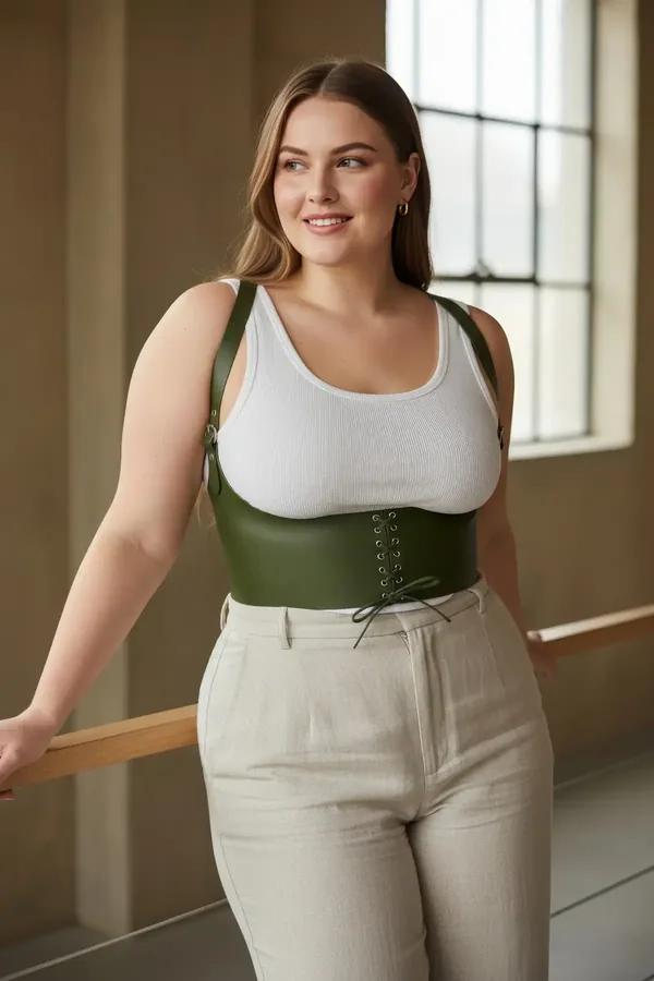 olive green faux leather lace-up underbust corset harness with adjustable shoulder straps worn over white ribbed tank top