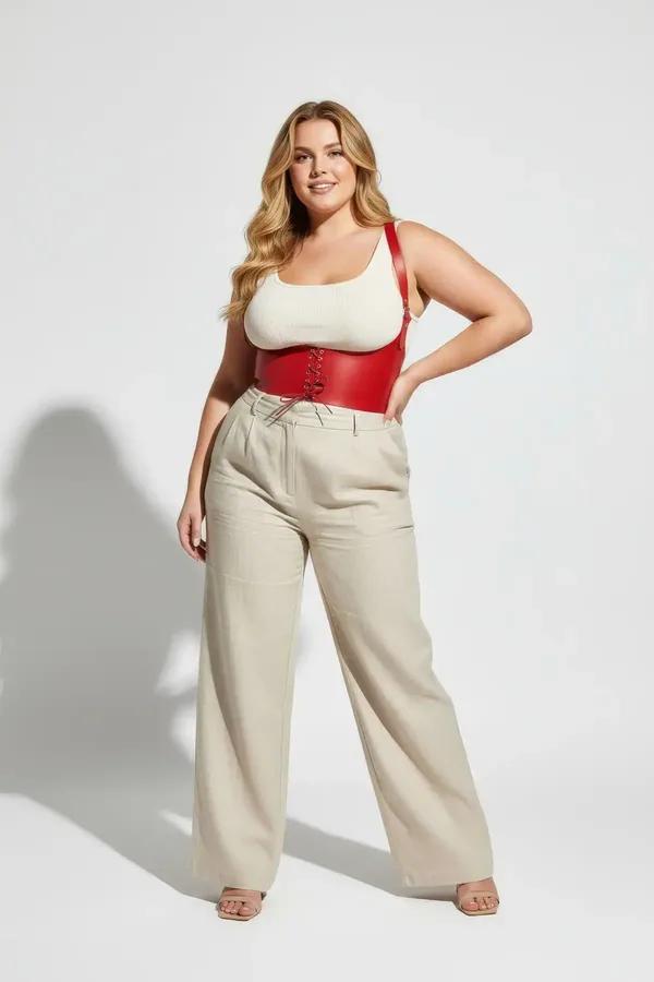 red faux leather corset belt with gold eyelets lace-up front and wide shoulder straps worn over cream tank top