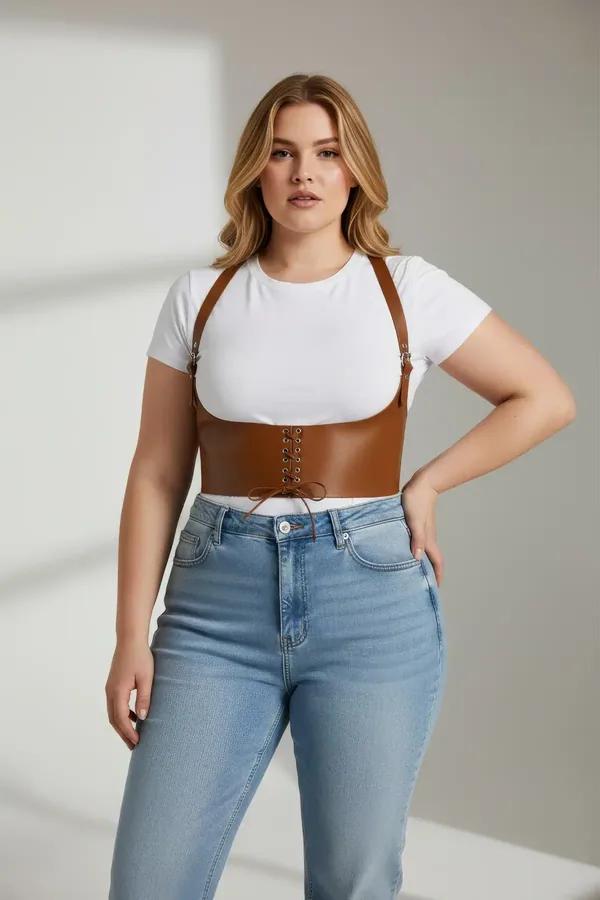 tan faux leather underbust corset harness with front lace-up eyelets and adjustable shoulder straps worn over white crop top