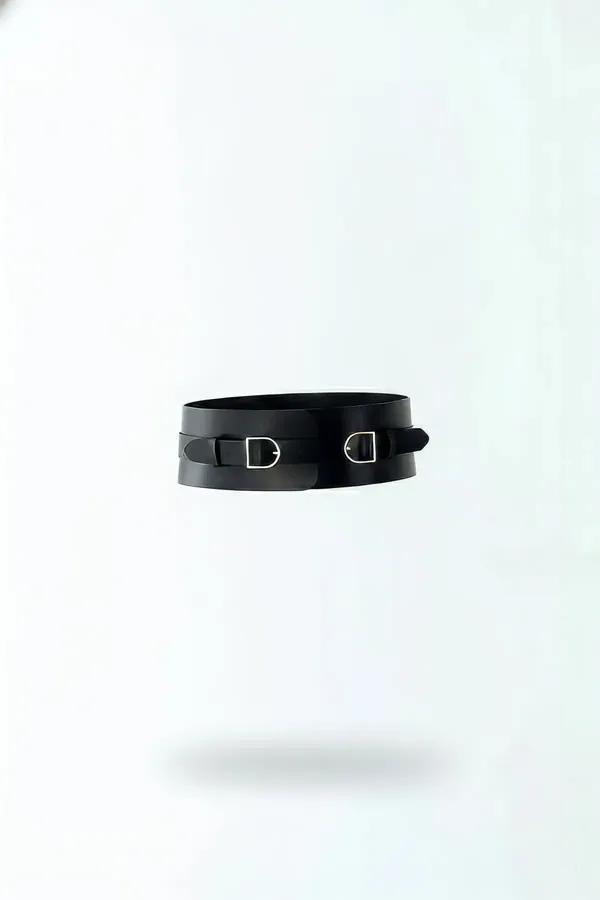 black wide faux leather waist harness belt with two silver D-frame buckles side by side on front panel