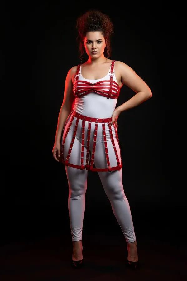red faux leather cage skirt and bra harness set with silver O-ring and stud hardware on plus-size model