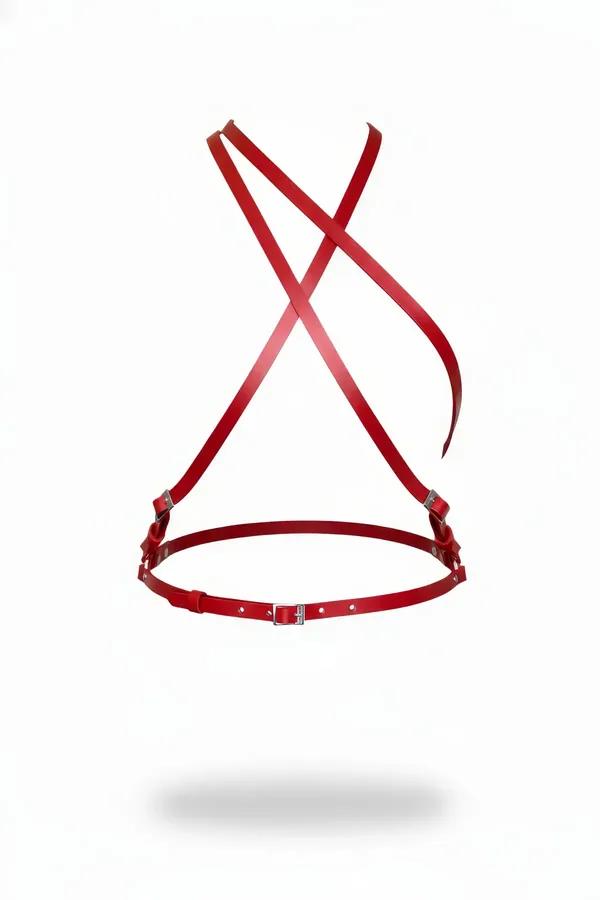 red faux leather chest harness with X-back crossing straps and silver side buckles on white background