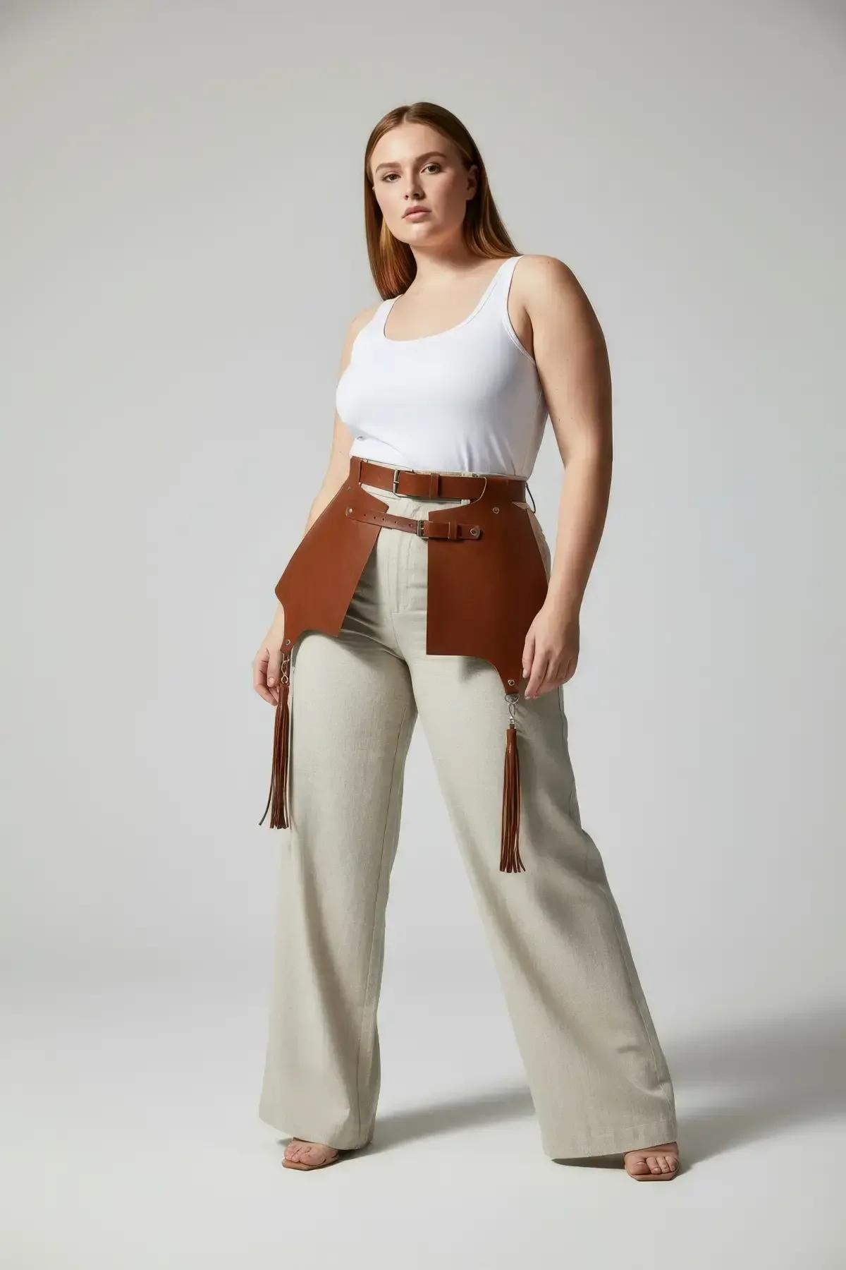 Close-up of tan leather tassel bundles and silver O-ring connectors on waist harness lower edge