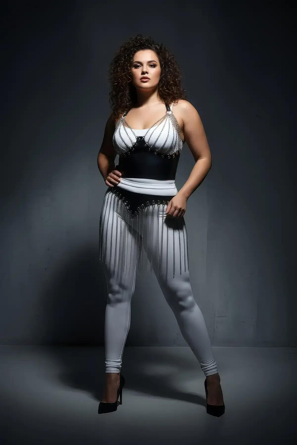 Full-length view of black chain fringe skirt cascading over white leggings with silver grommets