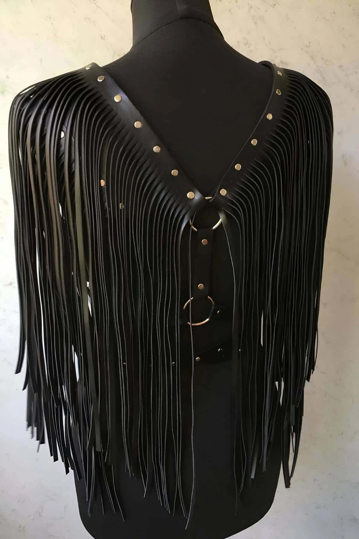 Püsküllü harness bel bandı yakın çekim, gümüş renkli metal toka ve çift perçinli şerit yapısı