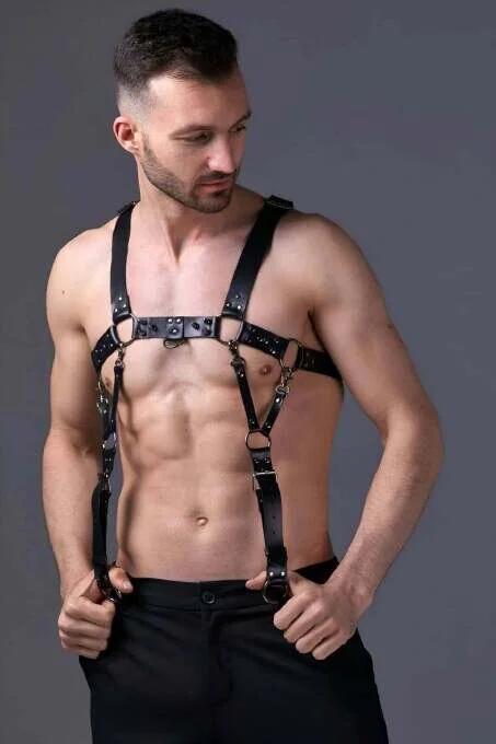 Close-up of 35 mm gold-tone O-ring connector on black faux leather chest harness center strap