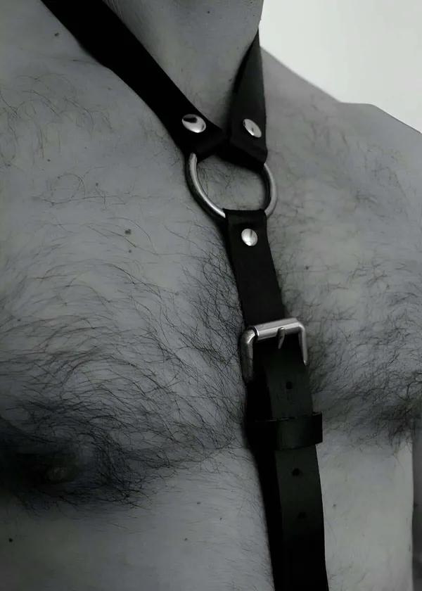 black faux leather o-ring chest harness with silver buckle adjustment worn on male torso